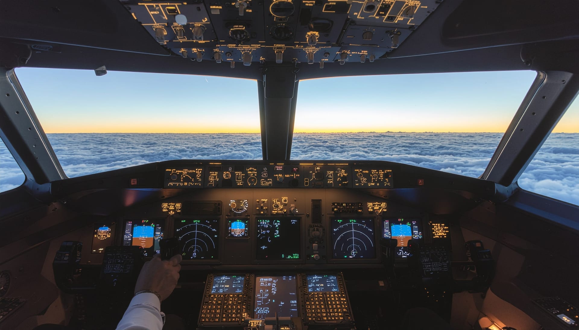 Wide-body airliner cockpit at dawn — captain's perspective above a cloud layer