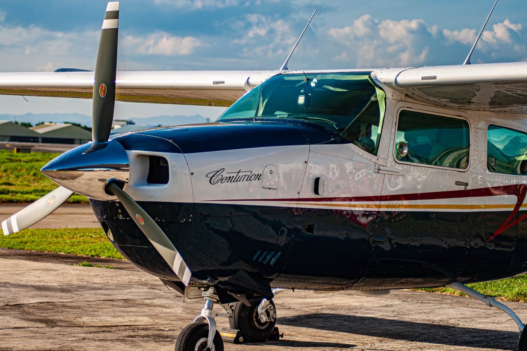 Cessna 210 Centurion — 3/4 front, three-blade propeller, 'Centurion' wordmark on fuselage